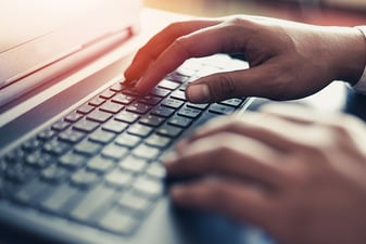 two hands gently placed on top of a keyboard